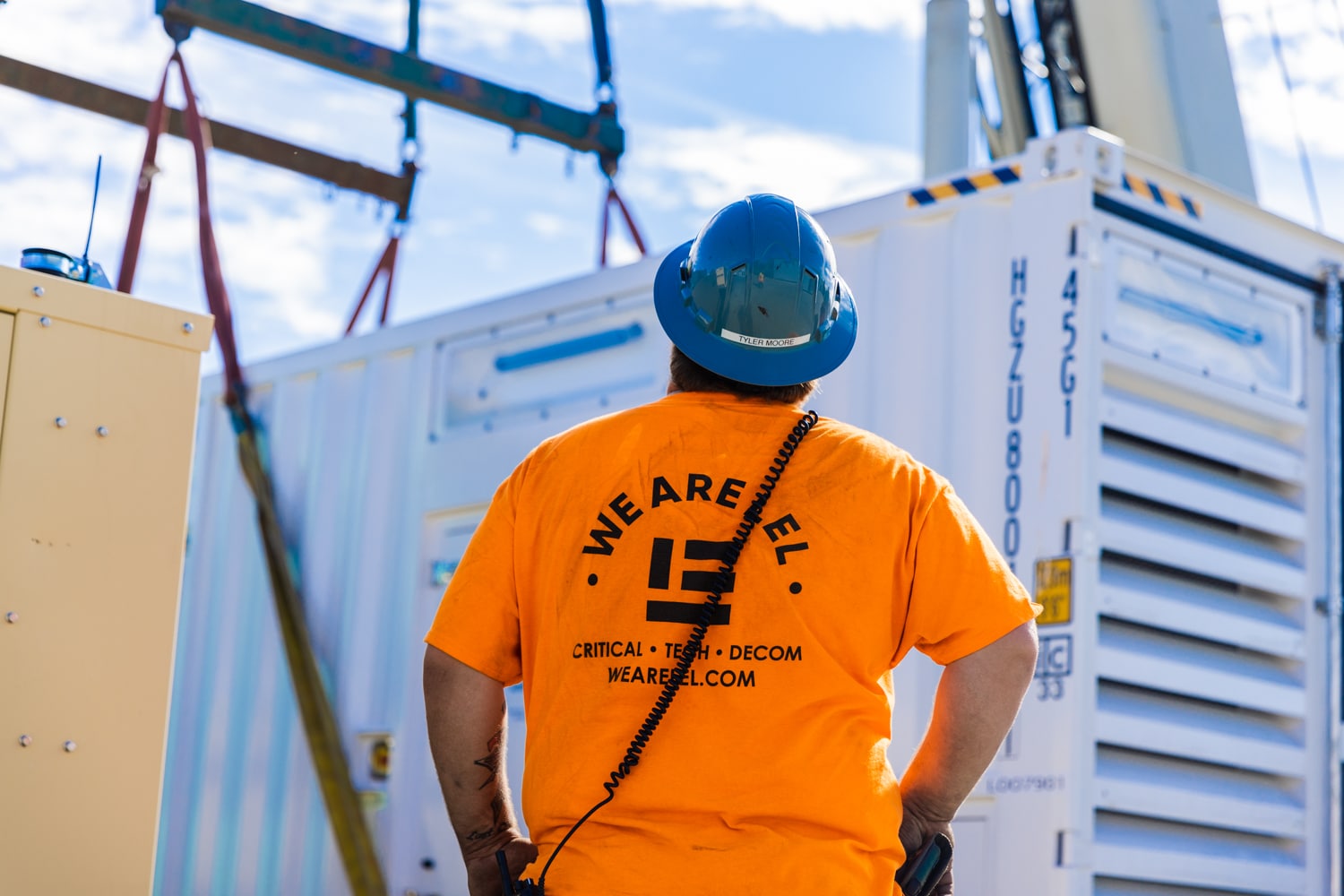 LEL Employee watches crane lifting mobile generator solution.